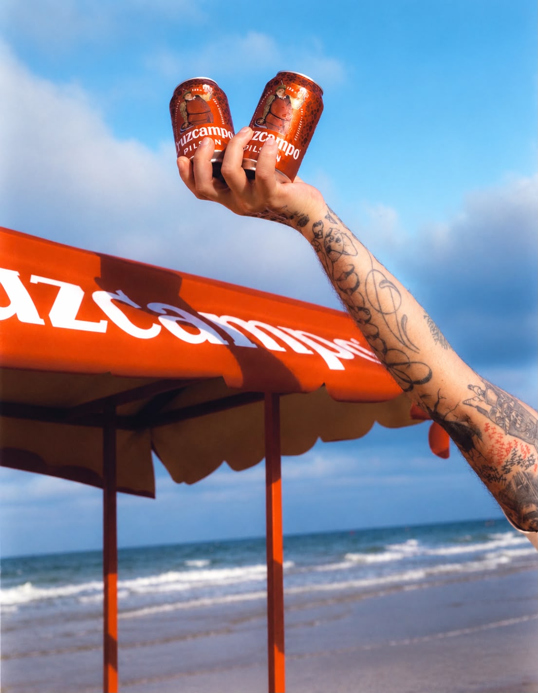 Dos latas de Cruzcampo levantadas junto al puesto de playa